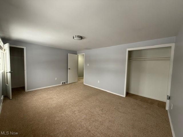 unfurnished bedroom featuring carpet floors and a closet