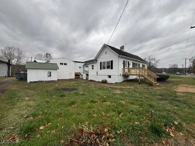 view of home's exterior with a wooden deck and a yard