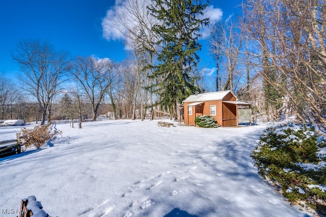 yard layered in snow with an outdoor structure