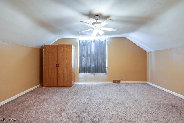 additional living space featuring carpet floors, vaulted ceiling, and ceiling fan