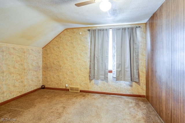 additional living space featuring ceiling fan, carpet, a textured ceiling, and vaulted ceiling