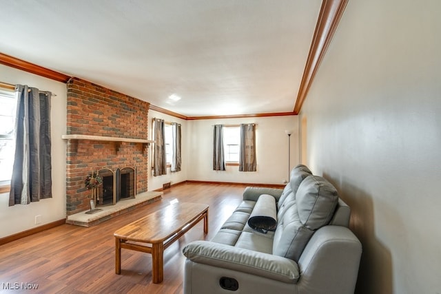 living room featuring hardwood / wood-style flooring, ornamental molding, and a fireplace