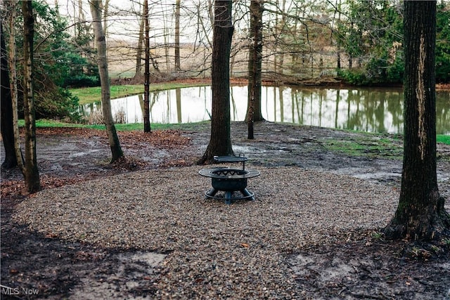 view of yard with a water view and an outdoor fire pit