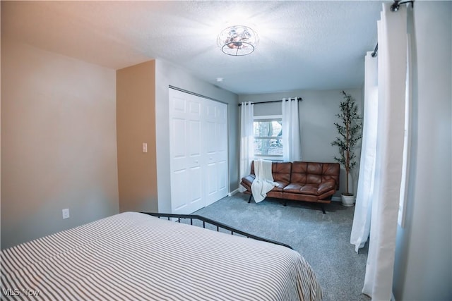 carpeted bedroom with a textured ceiling and a closet