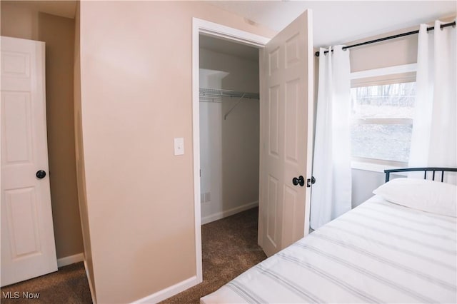 bedroom with a closet and dark colored carpet