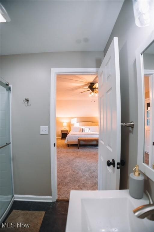 bathroom featuring ceiling fan, walk in shower, and sink