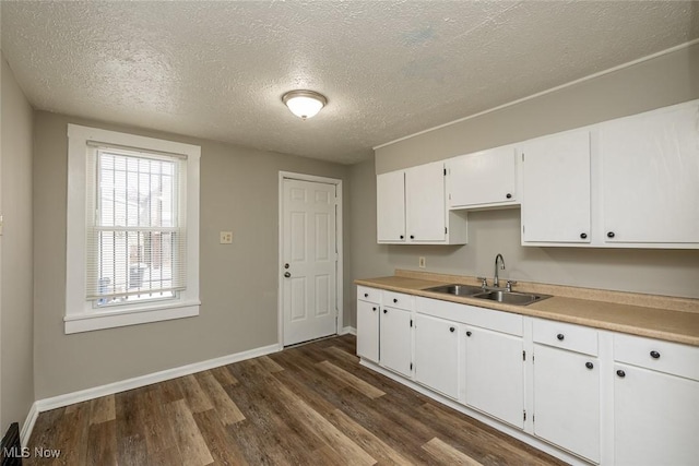 kitchen featuring a textured ceiling, dark hardwood / wood-style flooring, white cabinets, and sink