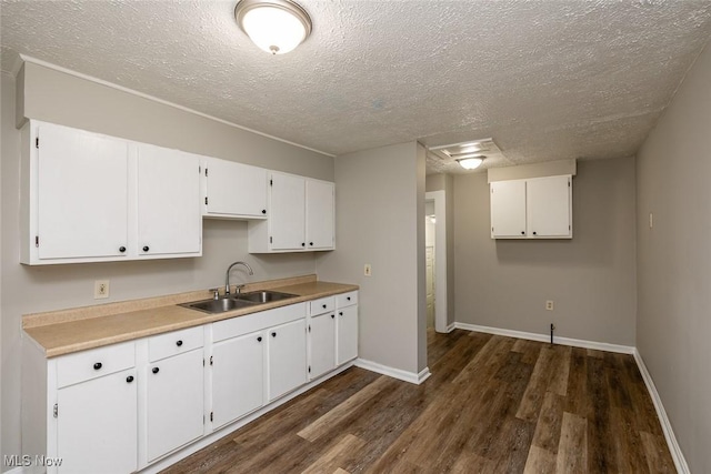 kitchen featuring sink, a textured ceiling, white cabinets, and dark hardwood / wood-style flooring