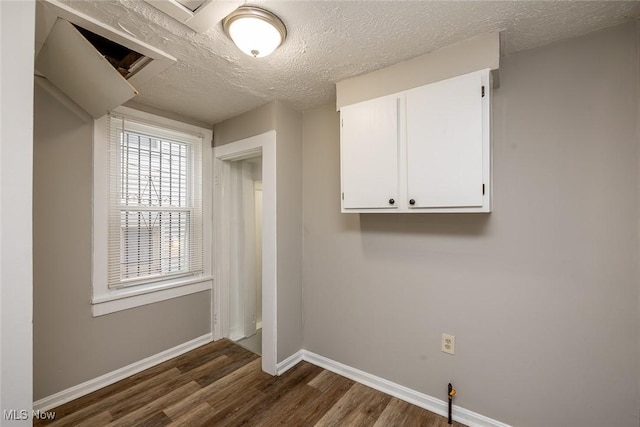 clothes washing area featuring dark hardwood / wood-style flooring and a textured ceiling