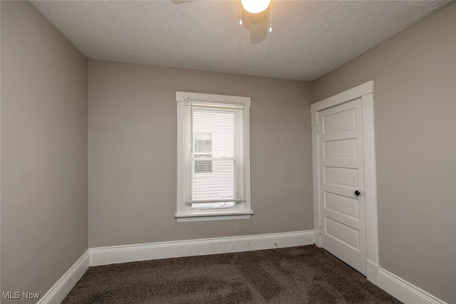 carpeted spare room featuring a textured ceiling and ceiling fan