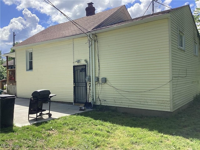 back of property with a patio area and a yard