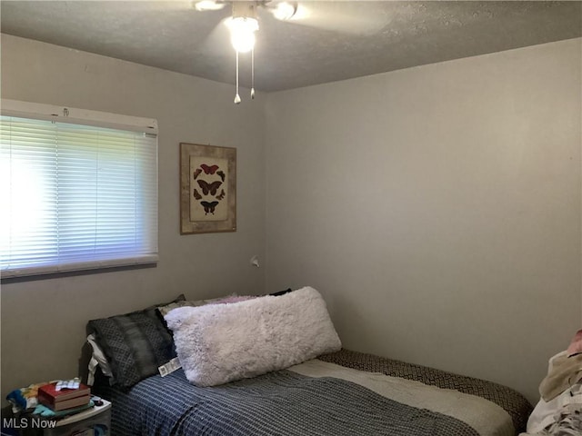 bedroom featuring ceiling fan and a textured ceiling