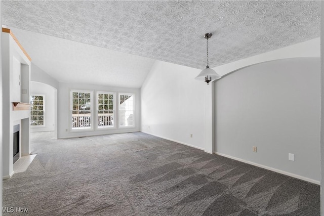 2834 Caxton Cir, Akron, OH 44312 - unfurnished living room with baseboards, a fireplace with flush hearth, vaulted ceiling, a textured ceiling, and carpet flooring