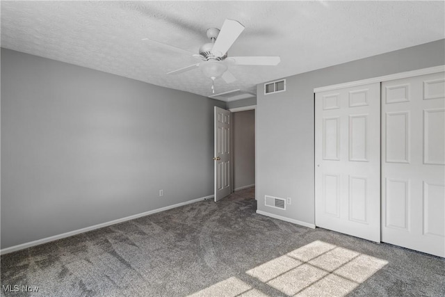 unfurnished bedroom featuring a textured ceiling, ceiling fan, a closet, and dark colored carpet