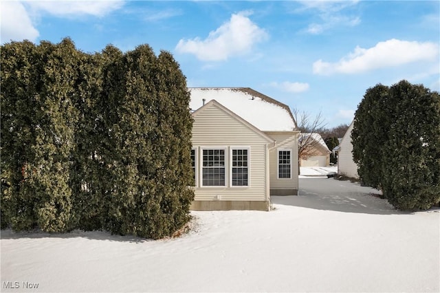 view of snow covered rear of property