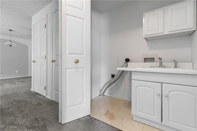 laundry area with washer hookup, a textured ceiling, light carpet, hookup for an electric dryer, and cabinets