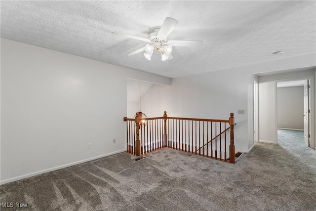 carpeted spare room featuring ceiling fan and a textured ceiling