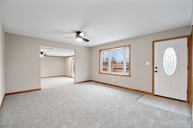 foyer featuring ceiling fan and light carpet