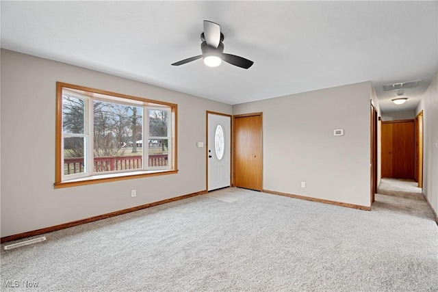 spare room featuring light carpet and ceiling fan