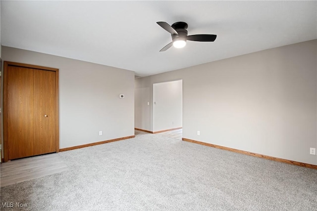 unfurnished bedroom with ceiling fan, a closet, and light carpet