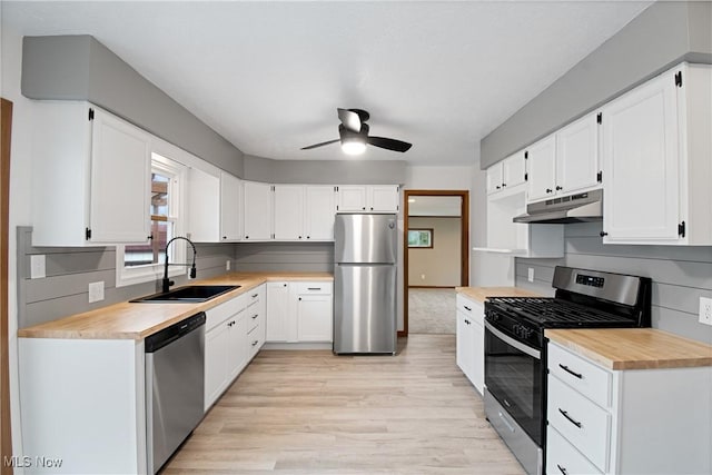 kitchen with stainless steel appliances, white cabinets, tasteful backsplash, and sink