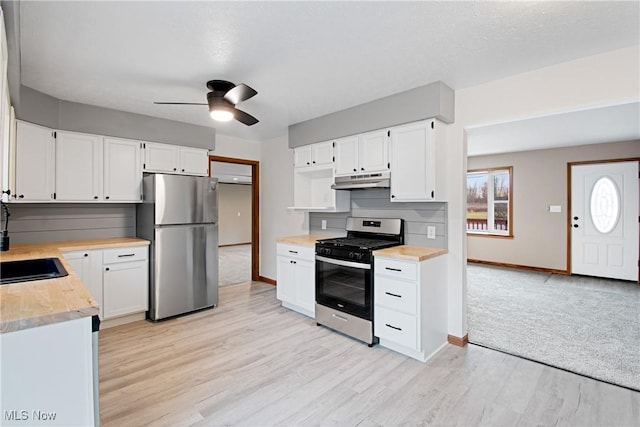 kitchen featuring light hardwood / wood-style floors, ceiling fan, appliances with stainless steel finishes, white cabinets, and sink