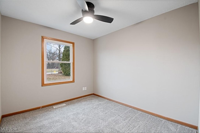 carpeted spare room featuring ceiling fan