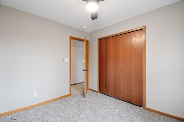 unfurnished bedroom featuring ceiling fan, light colored carpet, and a closet