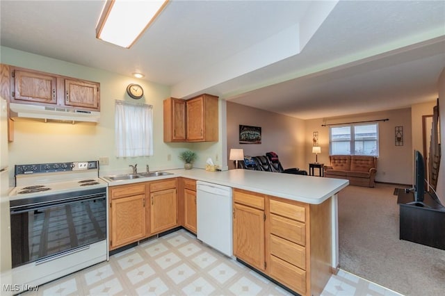 kitchen with sink, light colored carpet, kitchen peninsula, and white appliances