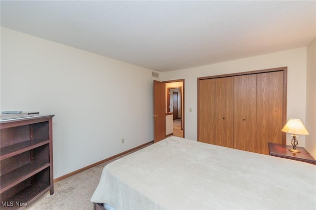 bedroom featuring light colored carpet and a closet