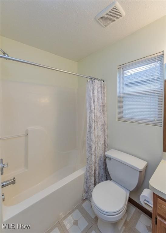 full bathroom with toilet, vanity, shower / bath combo with shower curtain, and a textured ceiling