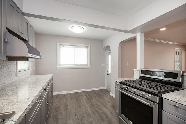 kitchen with gray cabinets, dark hardwood / wood-style floors, tasteful backsplash, gas range, and ornamental molding