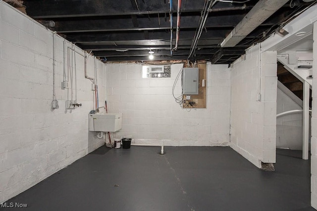 basement featuring electric panel and sink