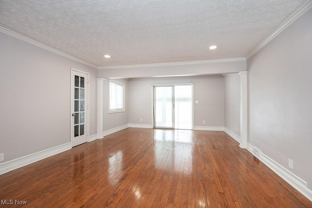 spare room with crown molding, a textured ceiling, and hardwood / wood-style floors