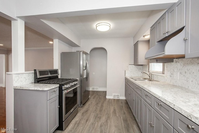 kitchen featuring appliances with stainless steel finishes, sink, gray cabinets, and light hardwood / wood-style floors