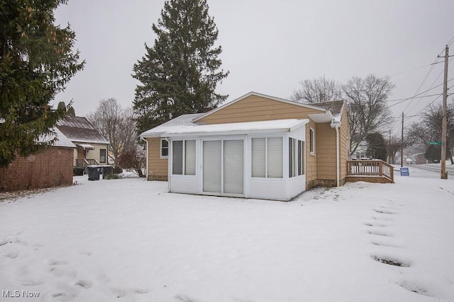 snow covered rear of property featuring a wooden deck