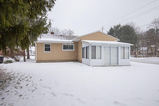 view of snow covered rear of property