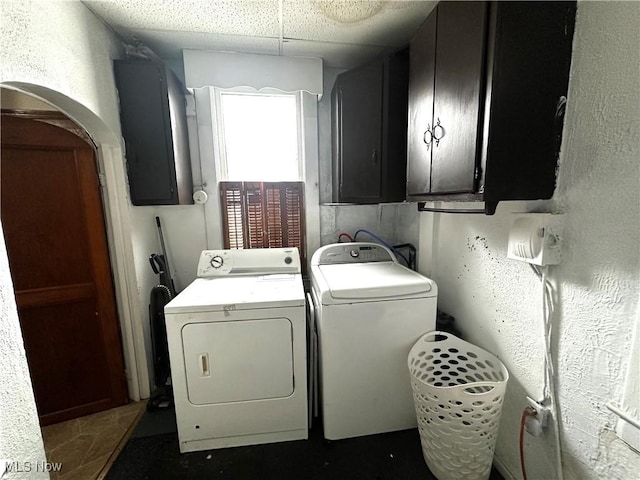 laundry room featuring cabinets, electric panel, and separate washer and dryer