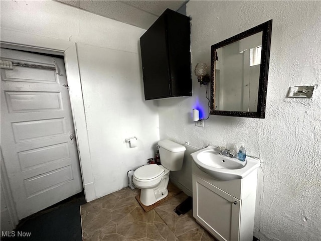 bathroom with toilet, vanity, and tile patterned floors