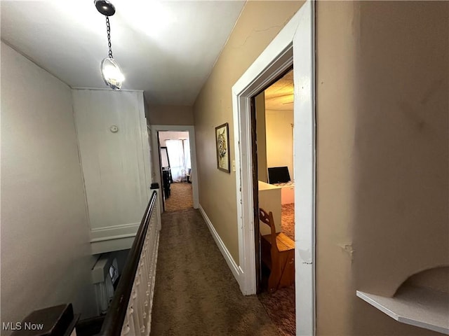 hallway with dark colored carpet