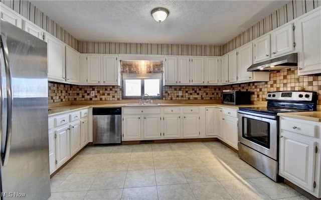 kitchen featuring sink, white cabinetry, a textured ceiling, stainless steel appliances, and light tile patterned floors