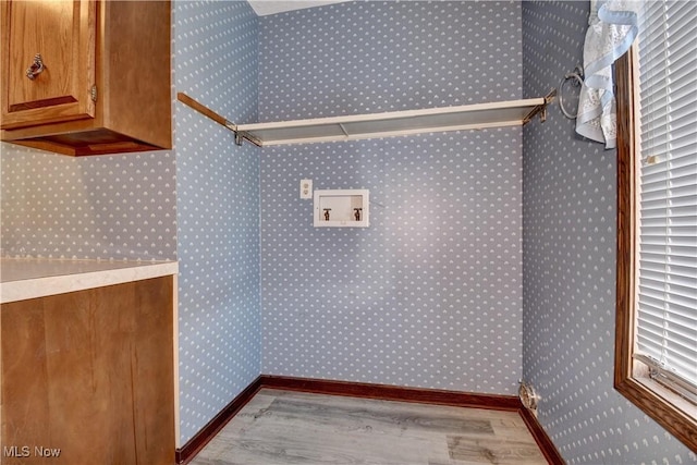 laundry room featuring light hardwood / wood-style floors, cabinets, and hookup for a washing machine