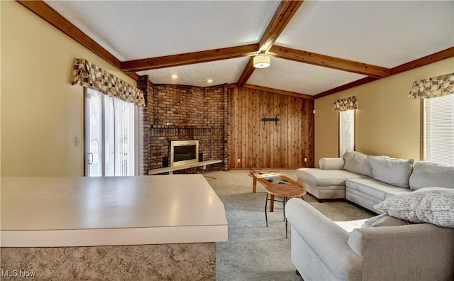 living room featuring light carpet, lofted ceiling with beams, a brick fireplace, and wood walls