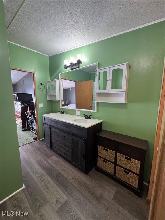 bathroom featuring hardwood / wood-style flooring, vanity, and a textured ceiling