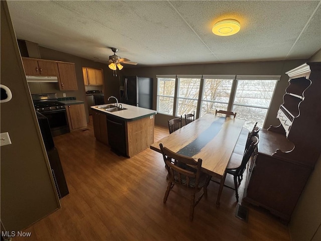 dining space featuring sink, hardwood / wood-style flooring, washer and clothes dryer, and a textured ceiling