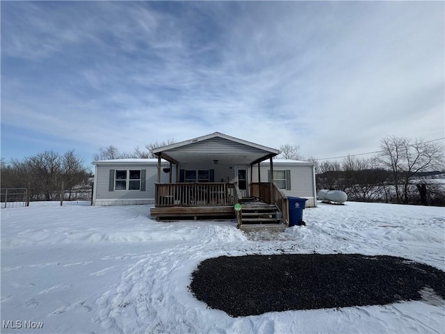 snow covered house featuring covered porch