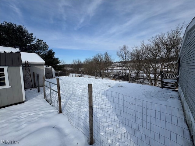 yard layered in snow with a shed