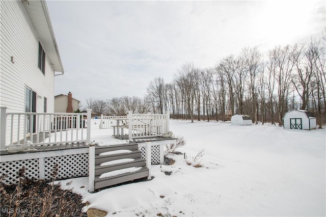 snow covered deck with a shed