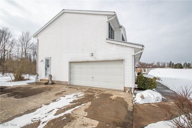 view of snowy exterior with a garage