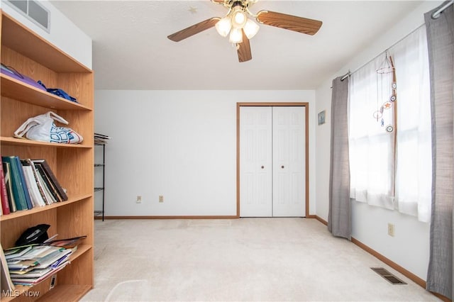 interior space featuring ceiling fan and light colored carpet